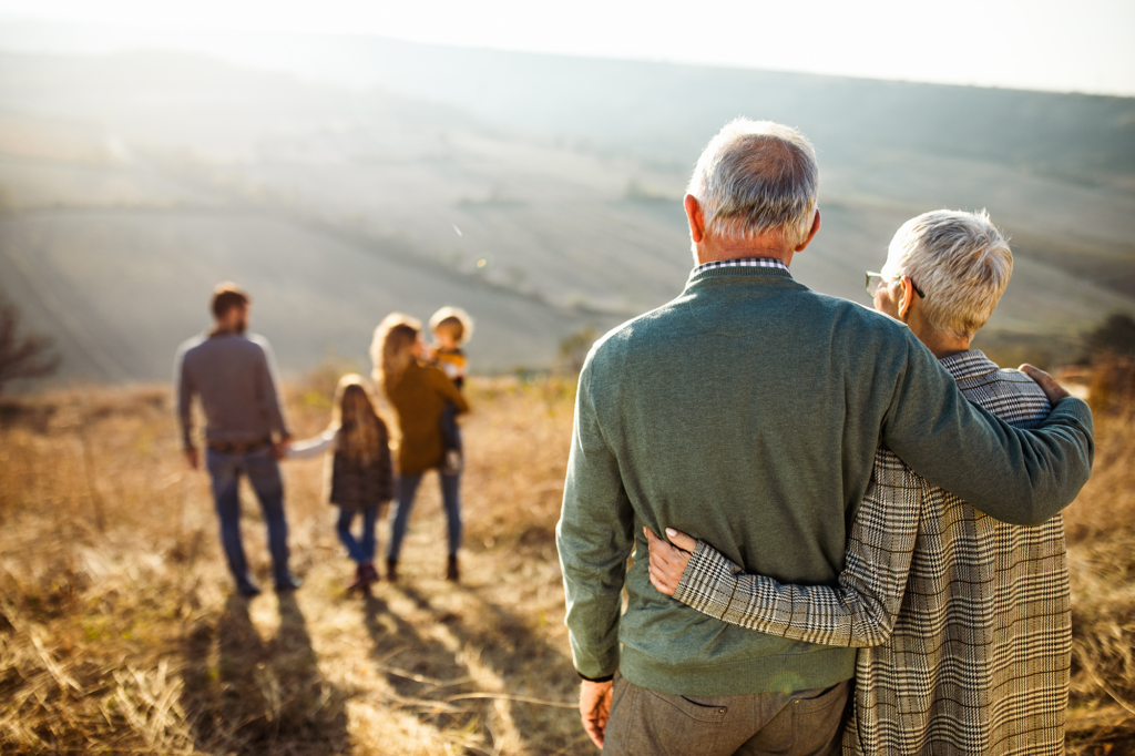 Senior couple watching family on hill