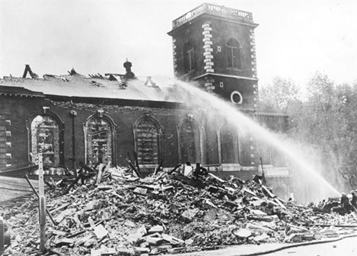 a fire engine sprays water on a bombed church